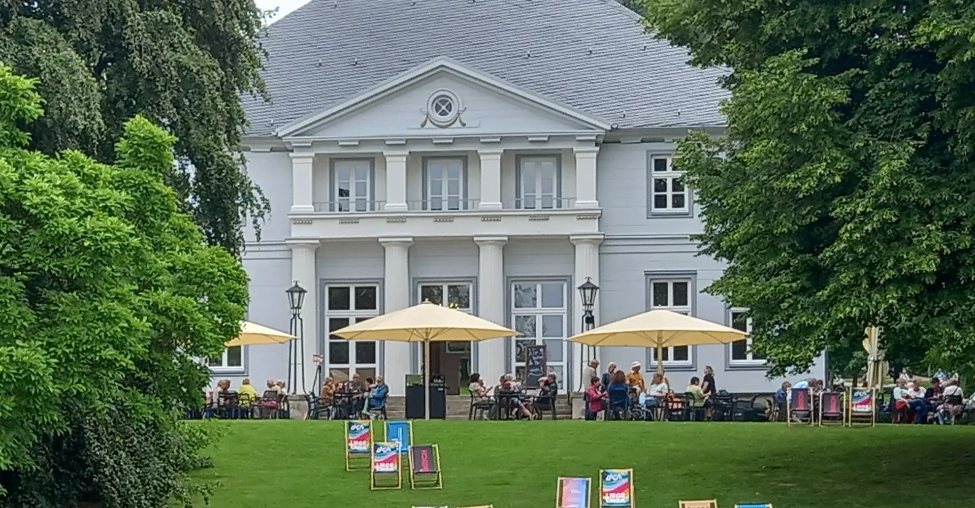 Schlösschen im Kurpark Bad Nenndorf mit Liegestühlen auf der Wiese