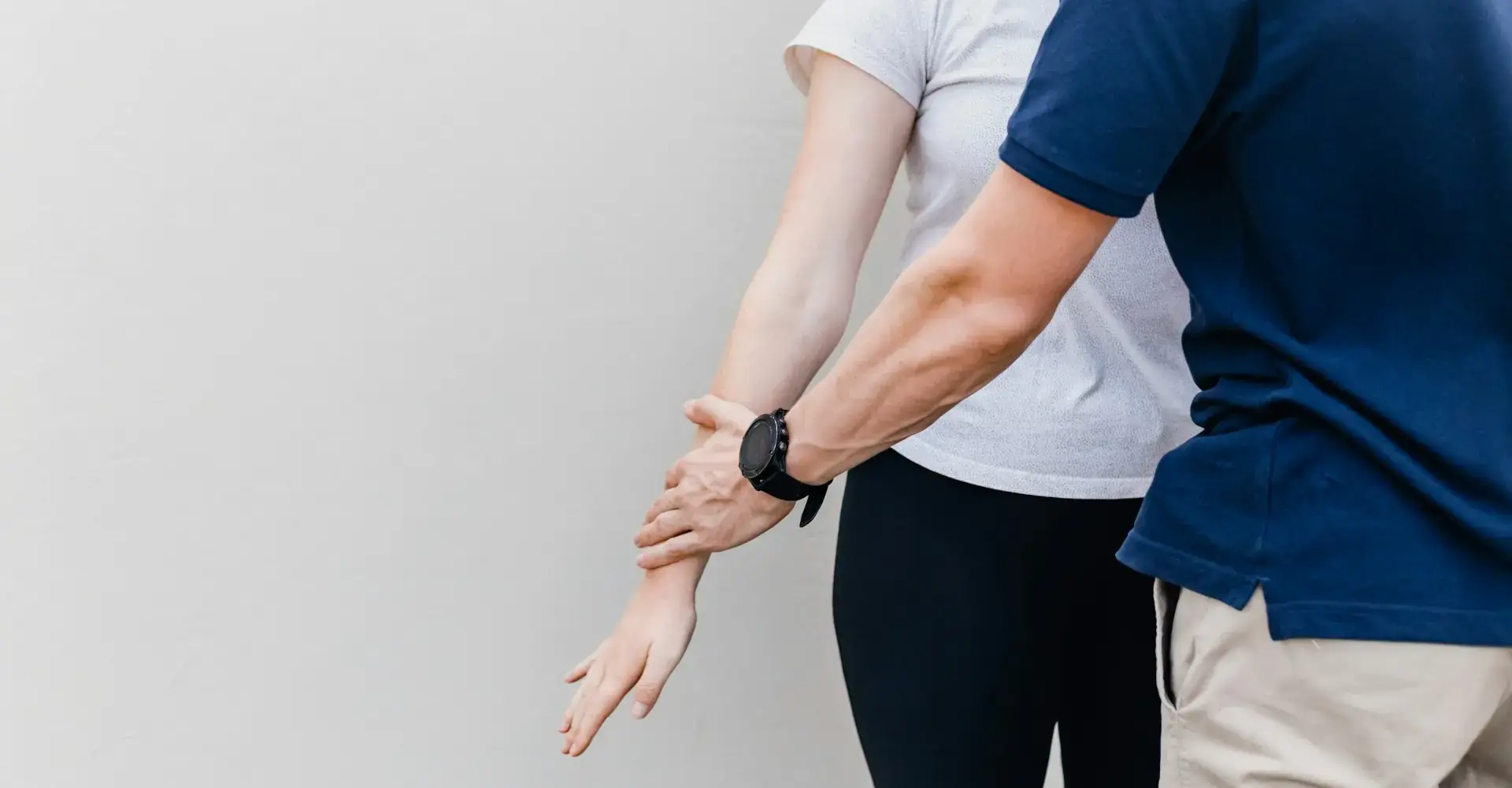 Physiotherapeut prüft die Beweglichkeit im Arm einer Patientin